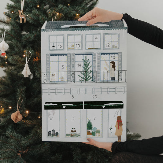 Eulenschnitt Adventskalender vor festlichem Weihnachtsbaum und Geschenken – liebevoll gestaltete Rückseite.