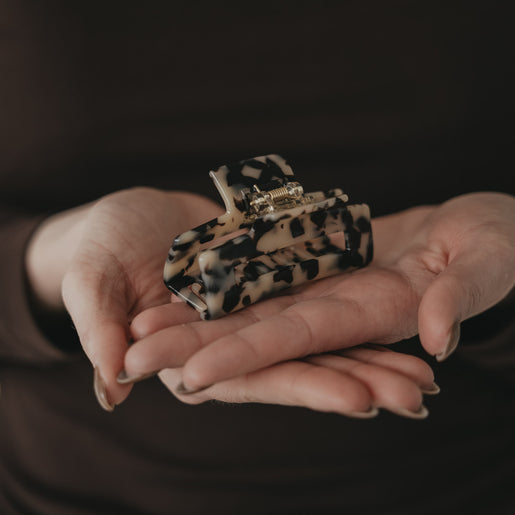 Große eckige Haarspange im Leo-Design in Händen präsentiert