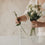 Glasvase mit schwarzen Herzen wird mit weißen Blumen bestückt