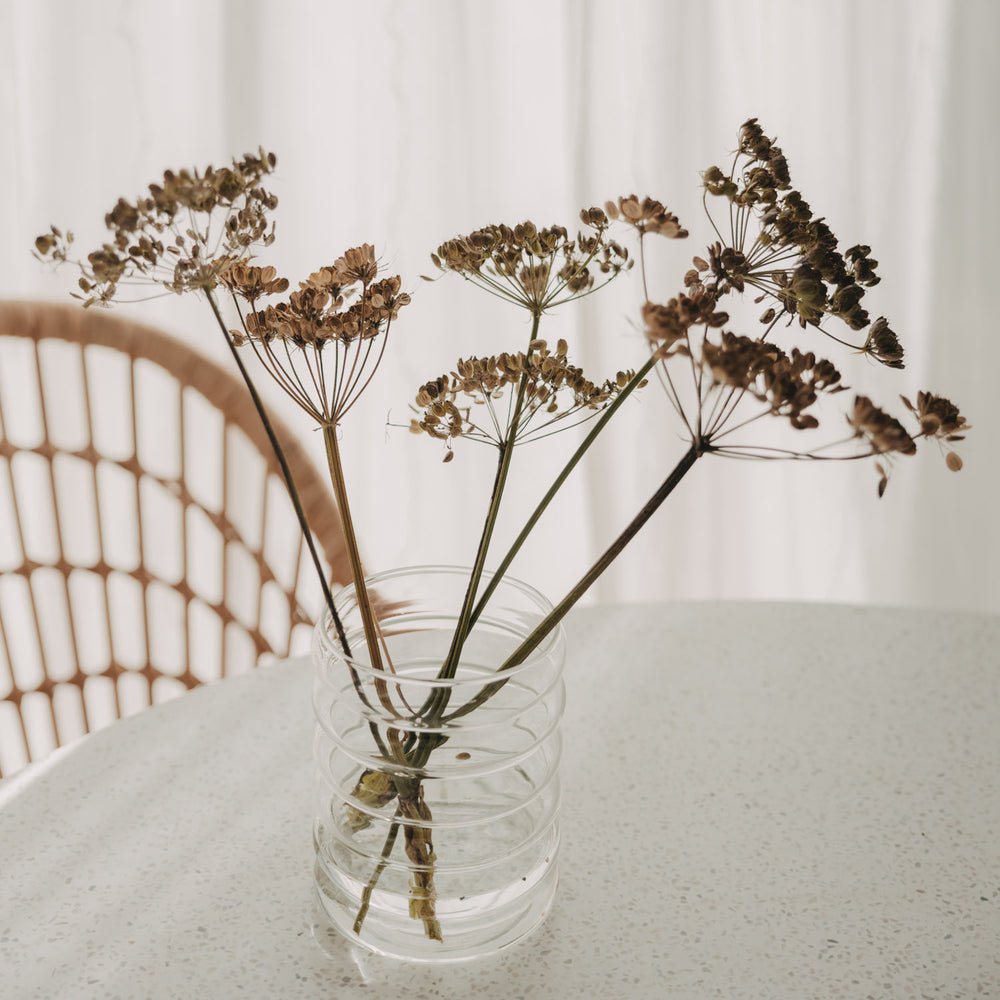 ransparente Bubble Glasvase mit Trockenblumen auf hellem Esstisch im skandinavischen Stil.