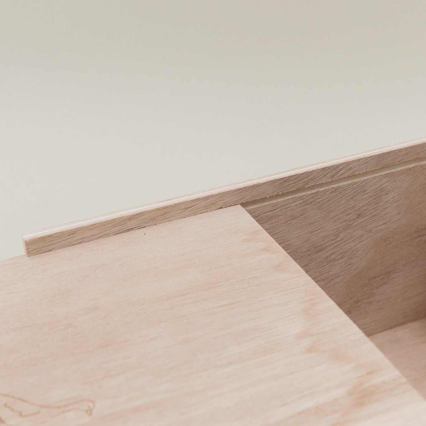 Nahaufnahme der Holzschiene der Erinnerungsbox, in die der Schiebedeckel eingesetzt wird.