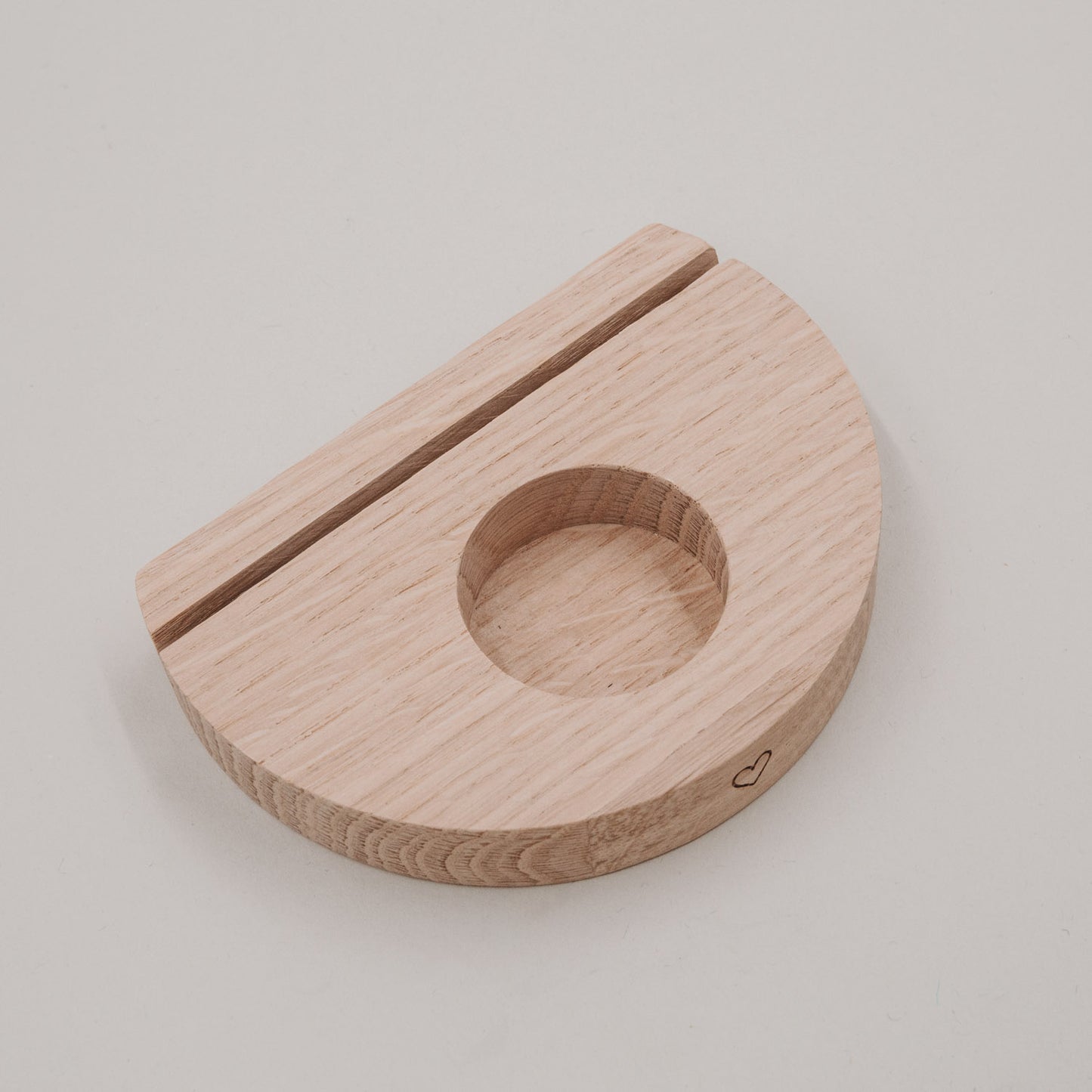 Halbmondförmiger Teelicht-Kartenhalter aus Holz mit Herzgravur auf hellem Hintergrund.