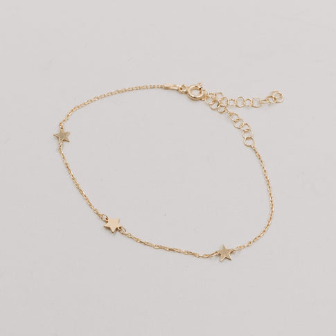 Produktbild des Armbands Jackie Gold flach liegend mit fünf kleinen Sternanhängern und verstellbarem Verschluss.
