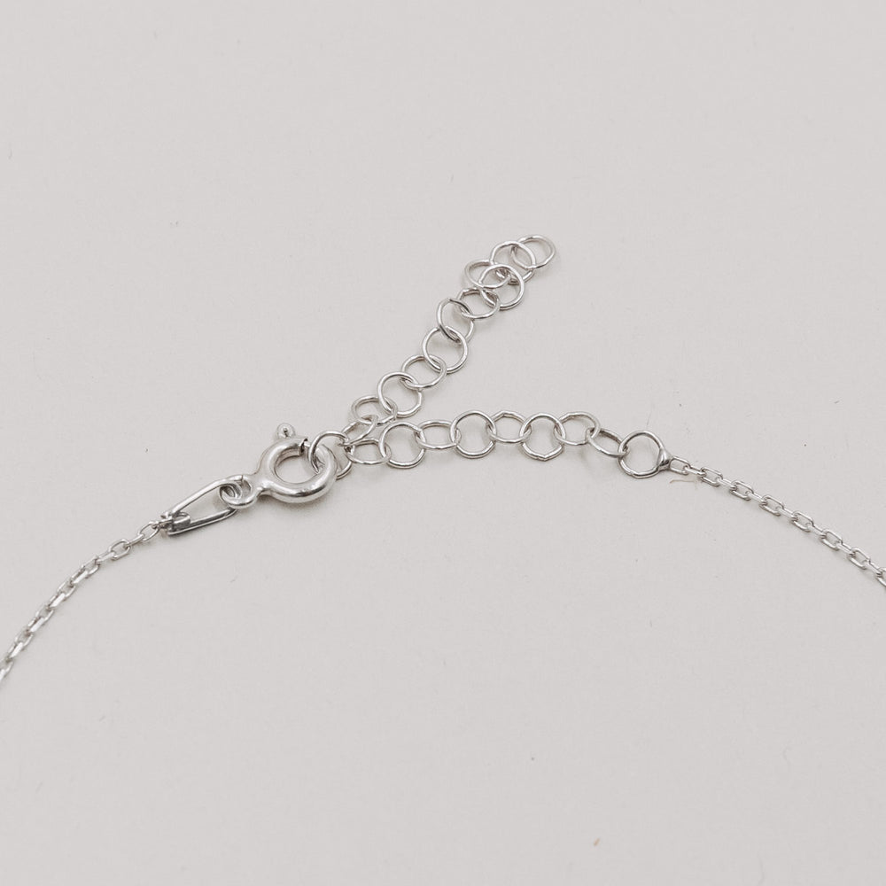 Detailaufnahme des silbernen Verschlusses und der Verlängerungskette des Armbands Jackie Silber.