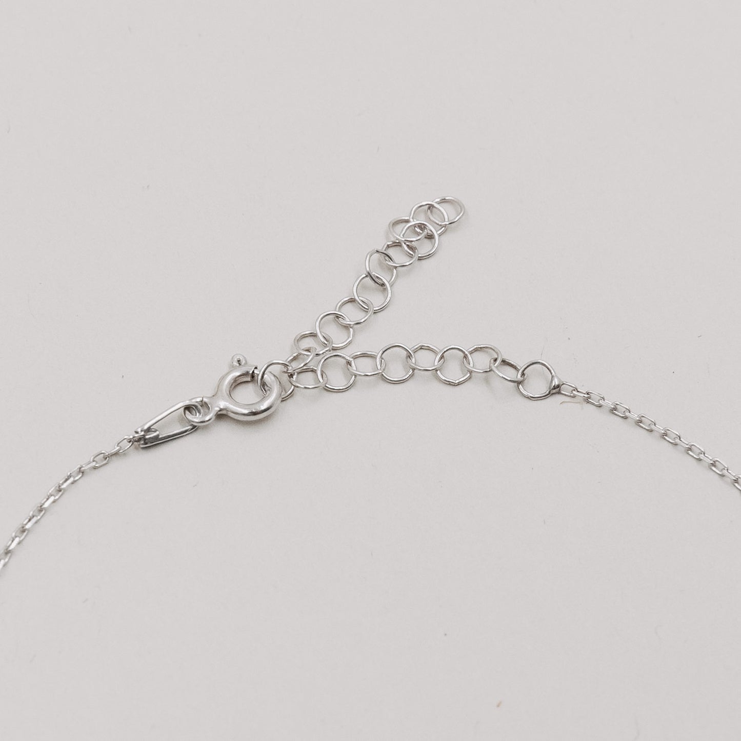 Detailaufnahme des silbernen Verschlusses und der Verlängerungskette des Armbands Jackie Silber.