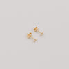 Paar goldene Stern-Ohrstecker Jackie Gold auf hellem Hintergrund, minimalistisches Schmuckdesign.