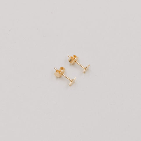 Paar goldene Stern-Ohrstecker Jackie Gold auf hellem Hintergrund, minimalistisches Schmuckdesign.