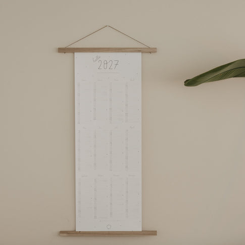Wandkalender 2027 aufgehängt mit Holzleiste im minimalistischen Stil