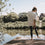 Frau auf Steg am See beim Yoga, lässiges weißes T-Shirt mit „go with the flow“ Rückendruck