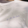 Detailansicht: weißes T-Shirt mit Schriftzug „go with the flow“ vorne
