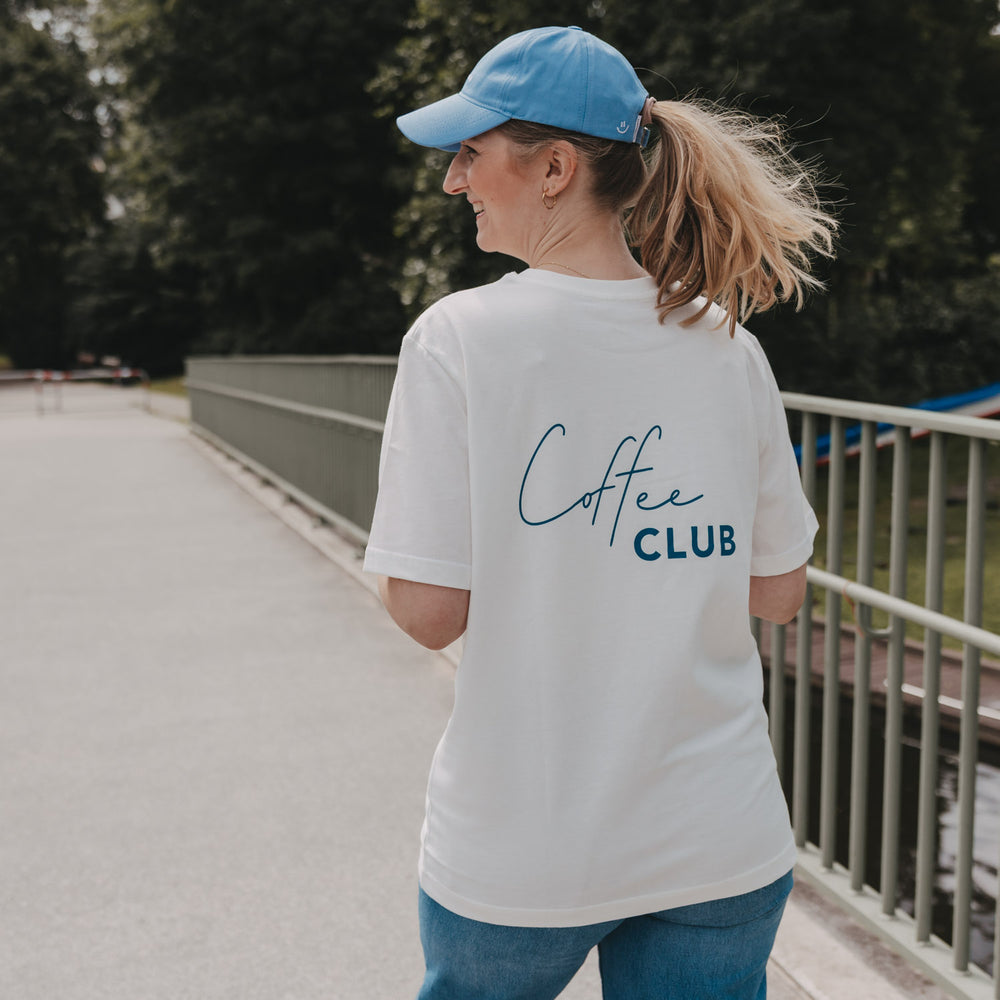 Frau trägt weißes Coffee Club T-Shirt beim Spaziergang, Rückenansicht