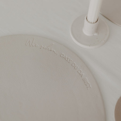 Detailaufnahme des Platzsets in Creme mit Schriftzug „Wie schön, dass du da bist“.