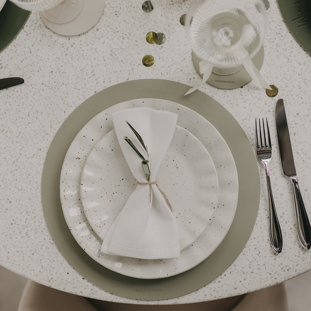 Gedeckter Tisch mit hellgrünem Platzset Herz Grün und Keramikgeschirr im natürlichen Look.