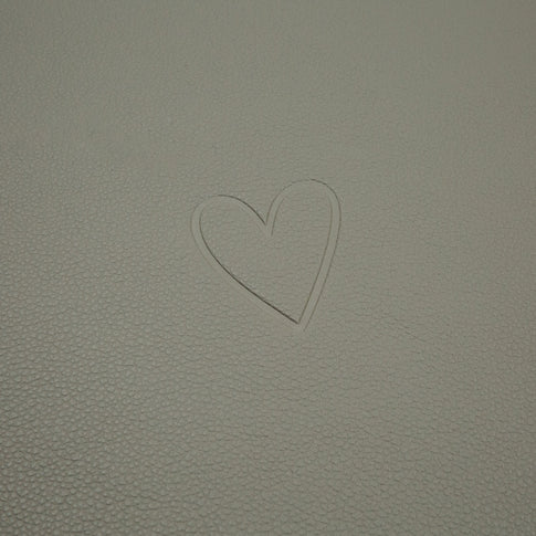 Prägung eines Herzsymbols auf der hellgrünen Oberfläche des wendbaren Platzsets Herz Grün.