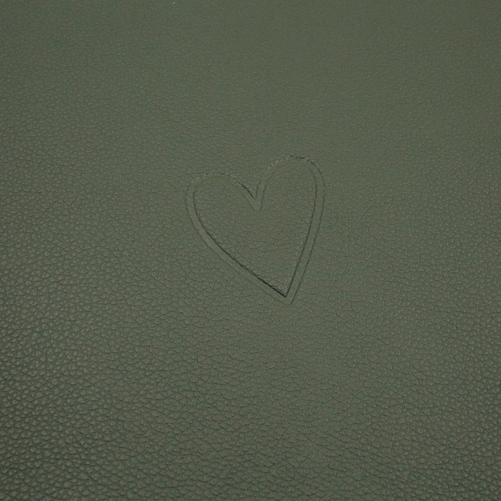 Eingeprägtes Herzmotiv auf der dunkleren grünen Seite des wendbaren Platzsets Herz Grün.