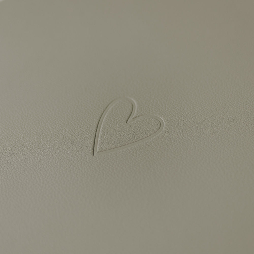 Nahaufnahme des eingeprägten Herzsymbols auf hellem grünen Platzset.