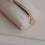 Detail der cremefarbenen Federtasche mit Herzprägung und goldenem Reißverschluss