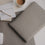 Laptop Sleeve grau mit geprägtem Herz von Eulenschnitt auf Schreibtisch mit Notizblock, Stift und Kaffee