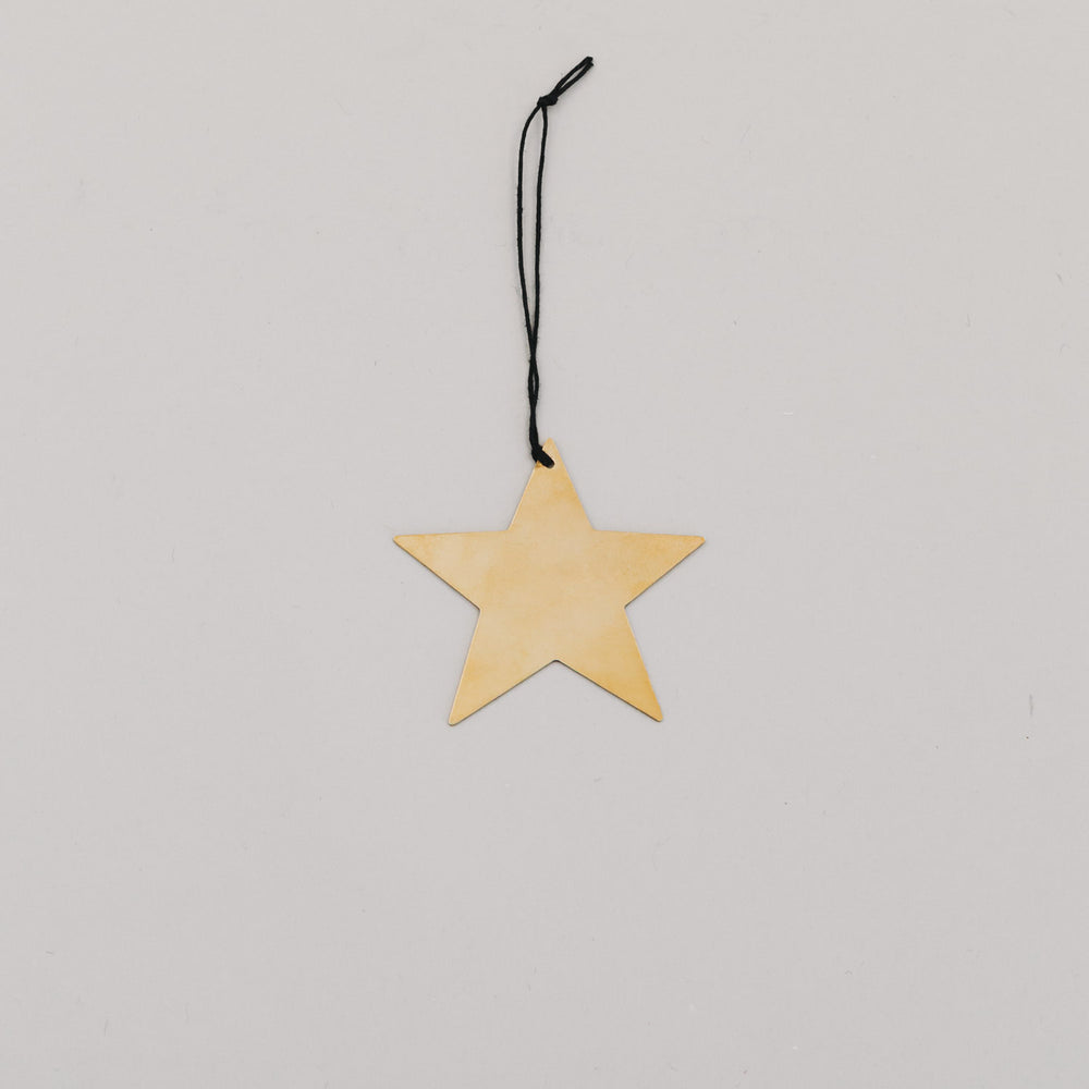 Goldener Metallstern mit schwarzem Band auf hellem Hintergrund – minimalistischer Dekoanhänger im Set.