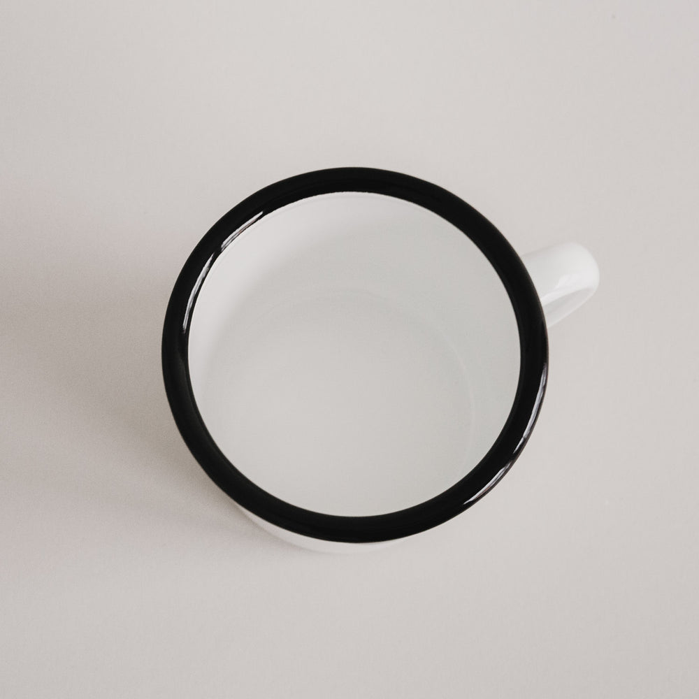 Emaille Tasse Herz von oben fotografiert – glänzend weißes Inneres mit schwarzem Rand.