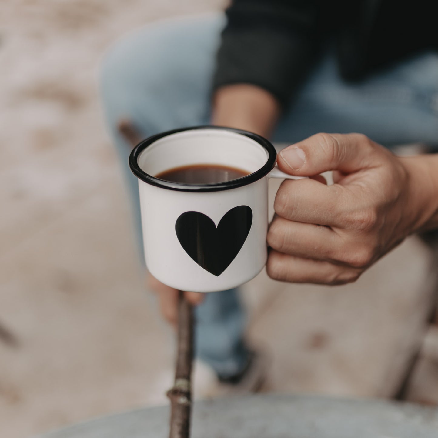 Hand hält Emaille Tasse Herz mit Kaffee – robust, pflegeleicht und ideal für Outdoor-Abenteuer.