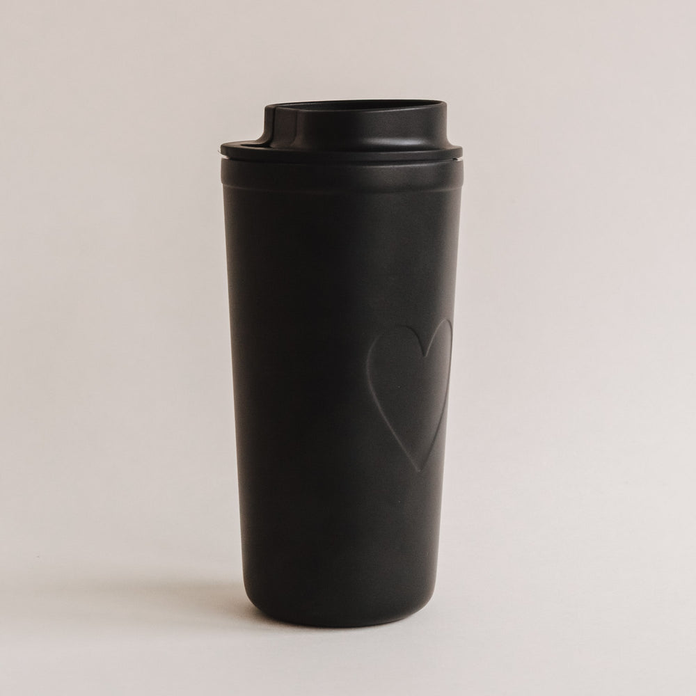 To-go Becher Herz schwarz freigestellt auf hellem Hintergrund, minimalistisches Design.