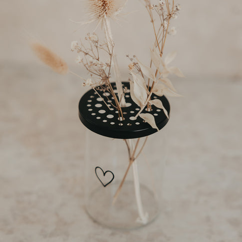 Glas-Blumenhalter mit schwarzem Lochdeckel und Trockenblumen, minimalistisches Herzdesign von Eulenschnitt.