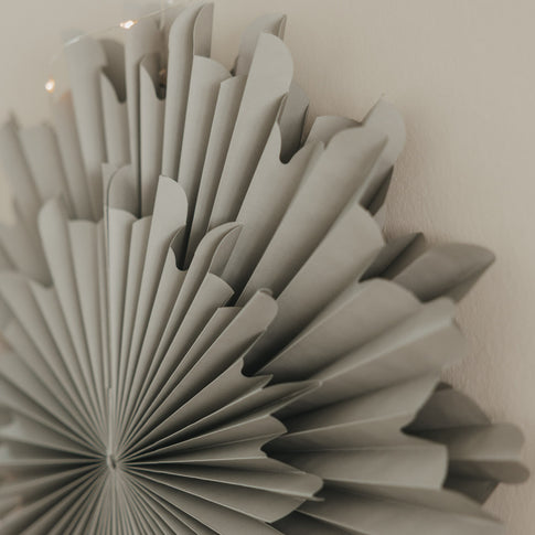 Graue Papierschneeflocke 45 cm als festliche Wanddekoration mit feinen Falten und Lichterkette