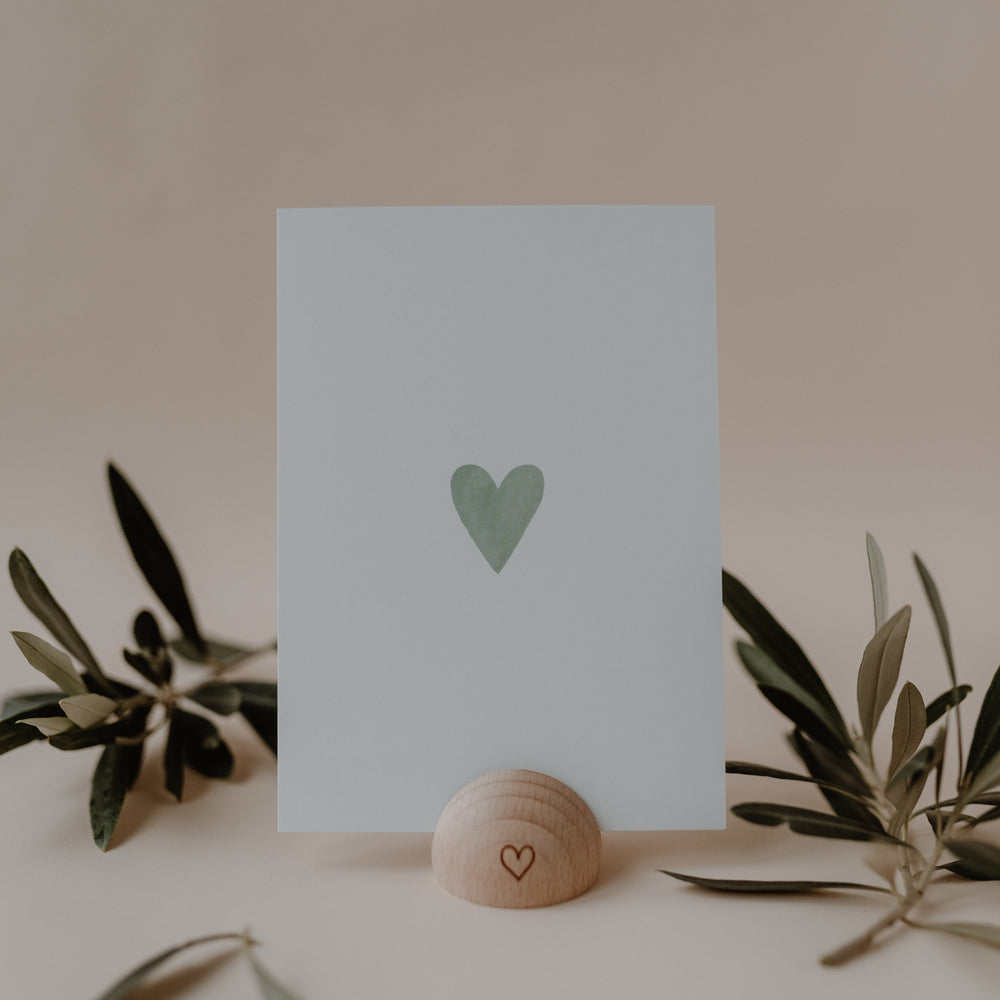 Minimalistische Eulenschnitt Aquarellkarte mit mintgrünem Herz, dekoriert mit Zweigen und einem Kartenhalter aus Holz.