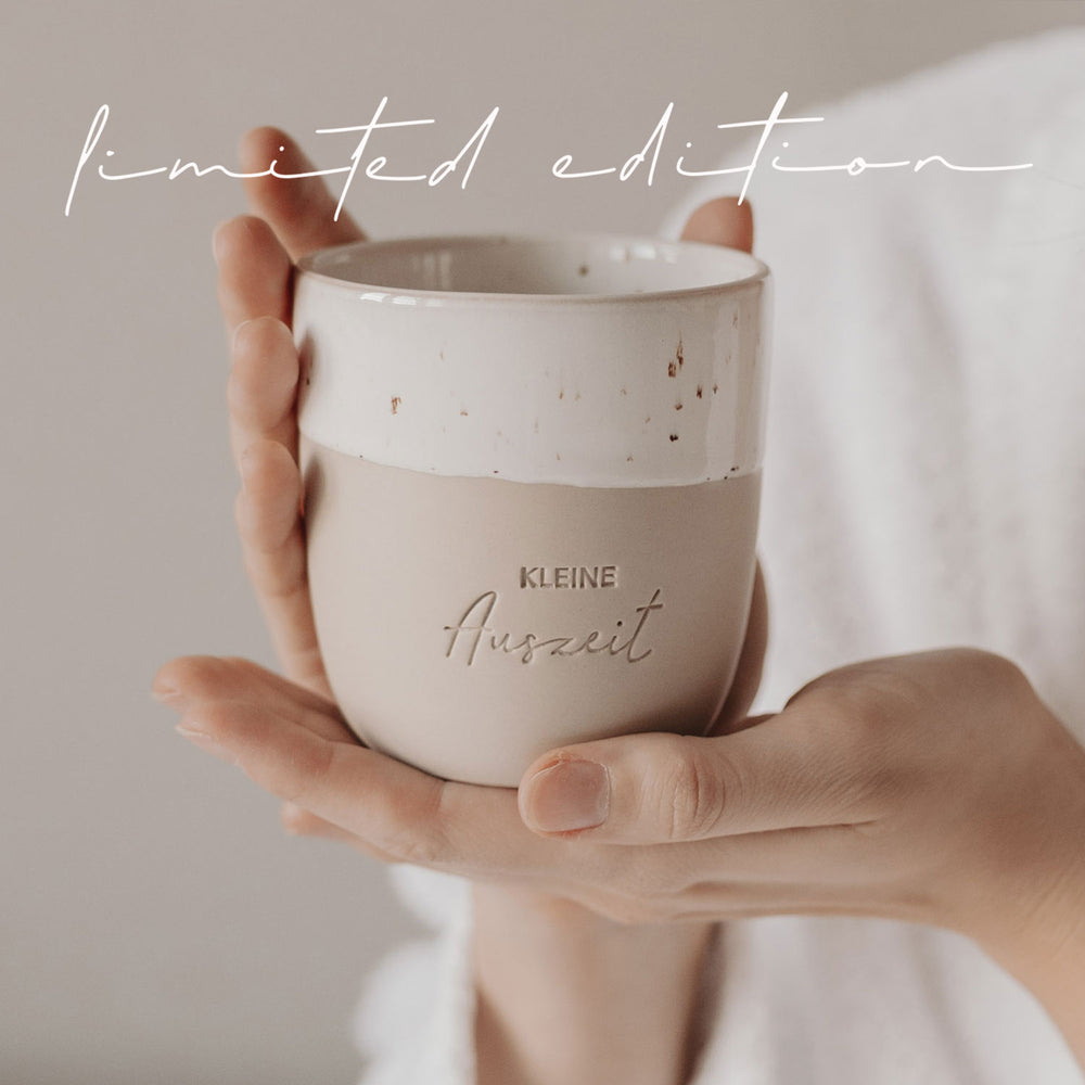 Keramikbecher „Kleine Auszeit“ wird in beiden Händen gehalten – Limited Edition.