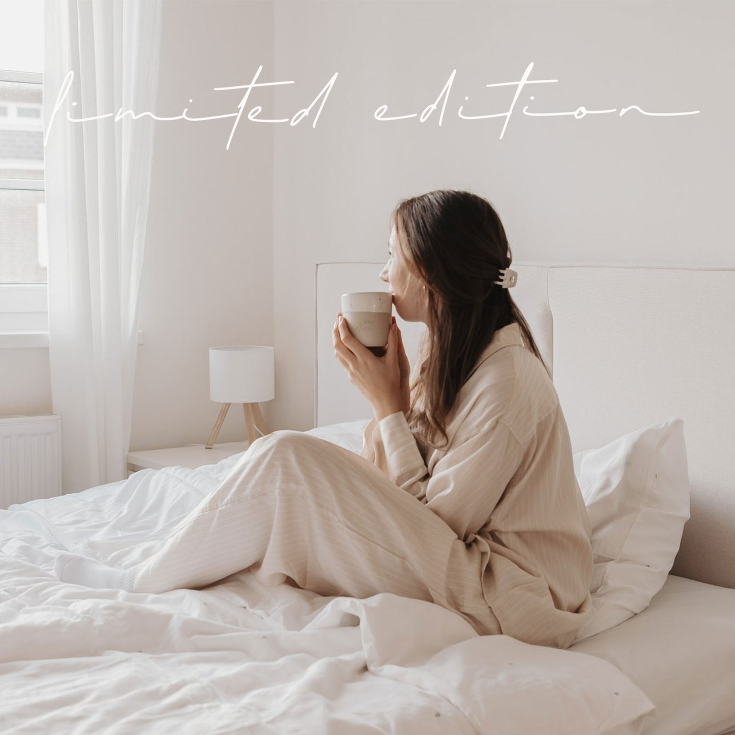 Frau im Bett mit Keramikbecher „Kleine Auszeit“ in heller, gemütlicher Atmosphäre – Limited Edition.