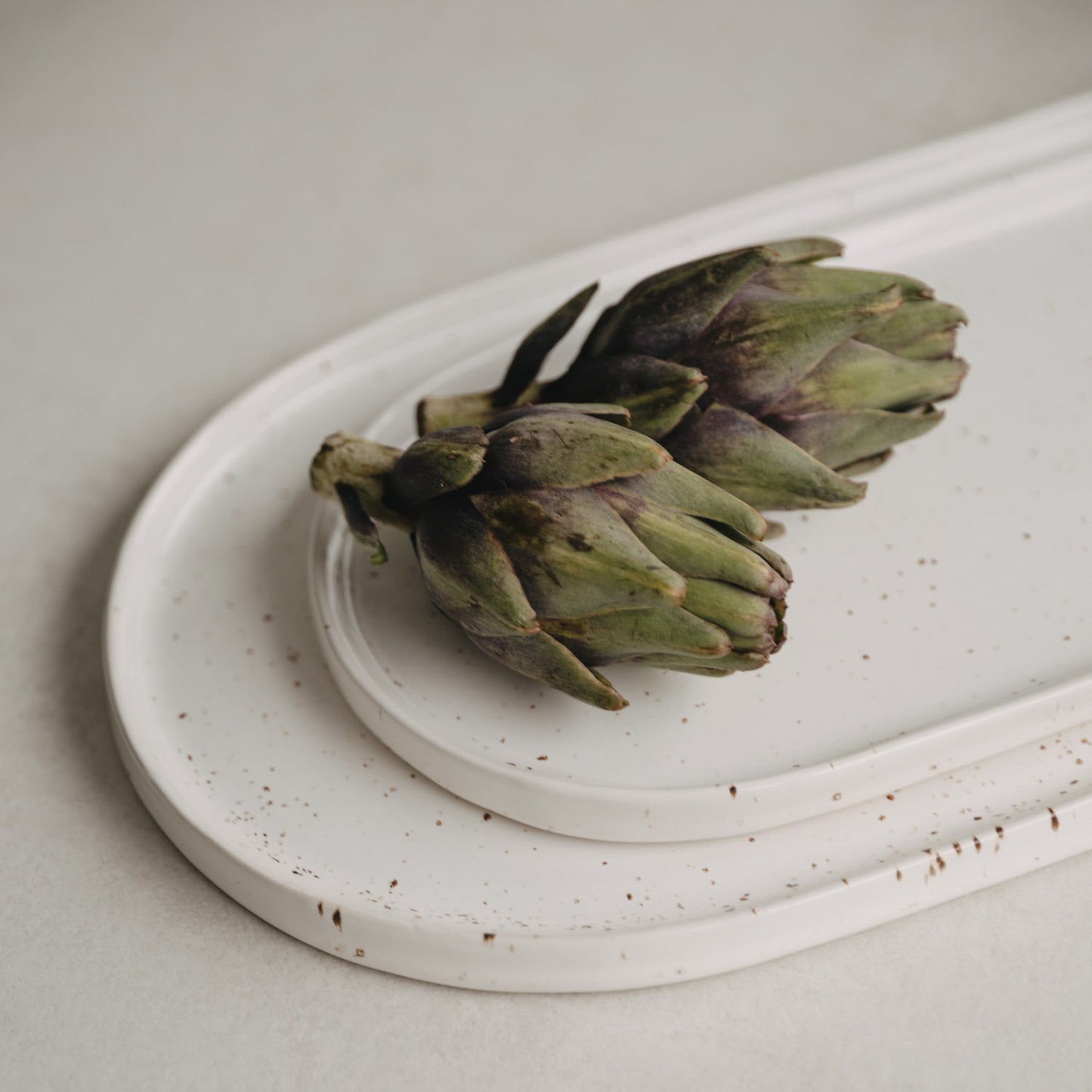 Artischocken dekorativ auf der großen und kleinen Servierplatte Calma arrangiert