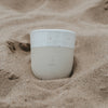 Steingutbecher Moin im Sand fotografiert mit nordischer Strandstimmung