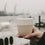 Becher Moin aus Steingut in der Hand gehalten mit Blick auf den Hamburger Hafen