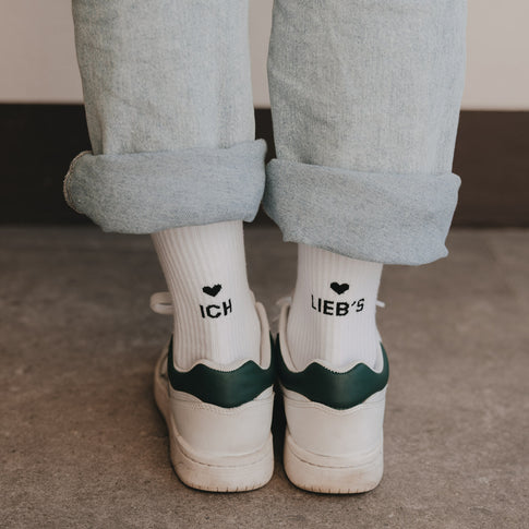 Rückansicht weißer Statement-Socken „Ich lieb’s“ kombiniert mit Sneakern und Jeans