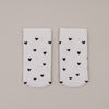 Flachliegende weiße Socken mit schwarzem Herzmuster minimalistisch präsentiert