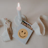 Geöffnete Smiley-Streichholzschachtel neben brennender Kerze und losen Streichhölzern.