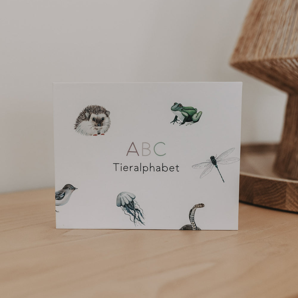 ABC Tieralphabet Box mit Tierillustrationen auf einem Holztisch.
