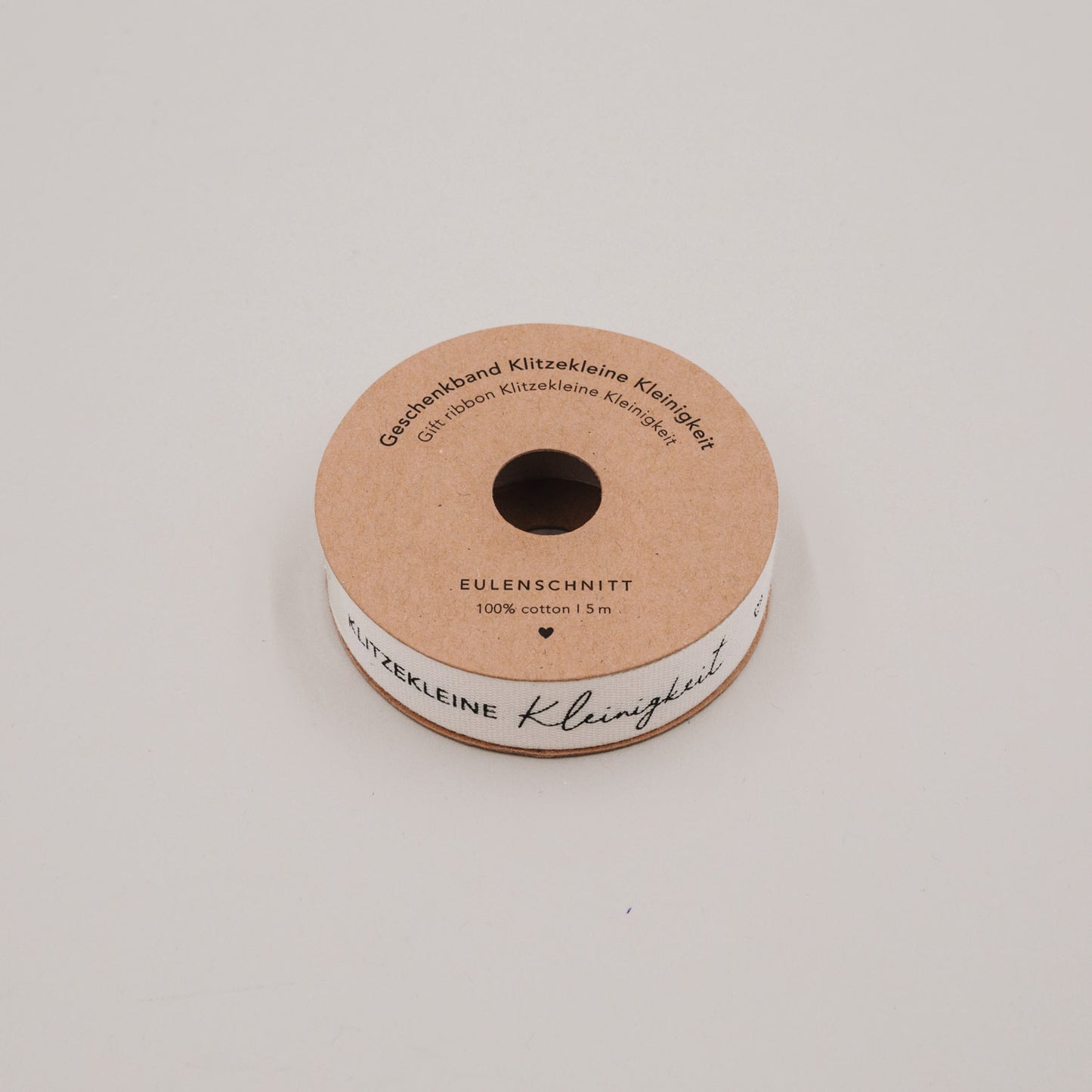 Geschenkband „Klitzekleine Kleinigkeit“ auf Rolle aus brauner Pappe, Schriftzug gut sichtbar