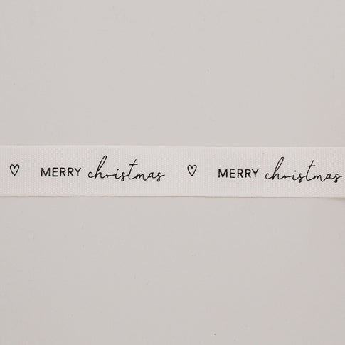 Detailaufnahme Geschenkband Merry Christmas mit Herzmotiv auf naturweißem Baumwollband