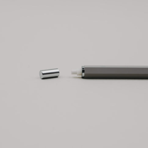 Grauer Druckbleistift mit abgenommener Kappe, sichtbar integriertem Radiergummi im Drücker.
