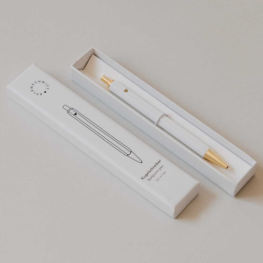 Weißer Kugelschreiber mit Herzdetail in Geschenkbox neben Verpackung von Eulenschnitt