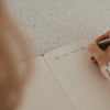 Liniertes A5 Notizbuch beim handschriftlichen Schreiben mit einem Stift