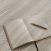 Offenes A5 Notizbuch mit linierten Seiten, schwarzem Leseband und Stift