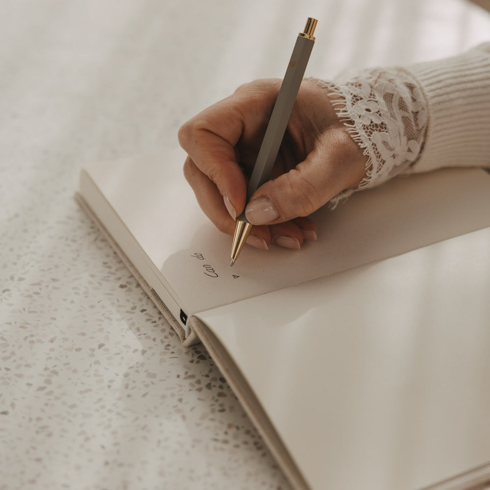 Gepunktetes A5 Notizbuch beim Schreiben mit Stift, Detailansicht der Seite
